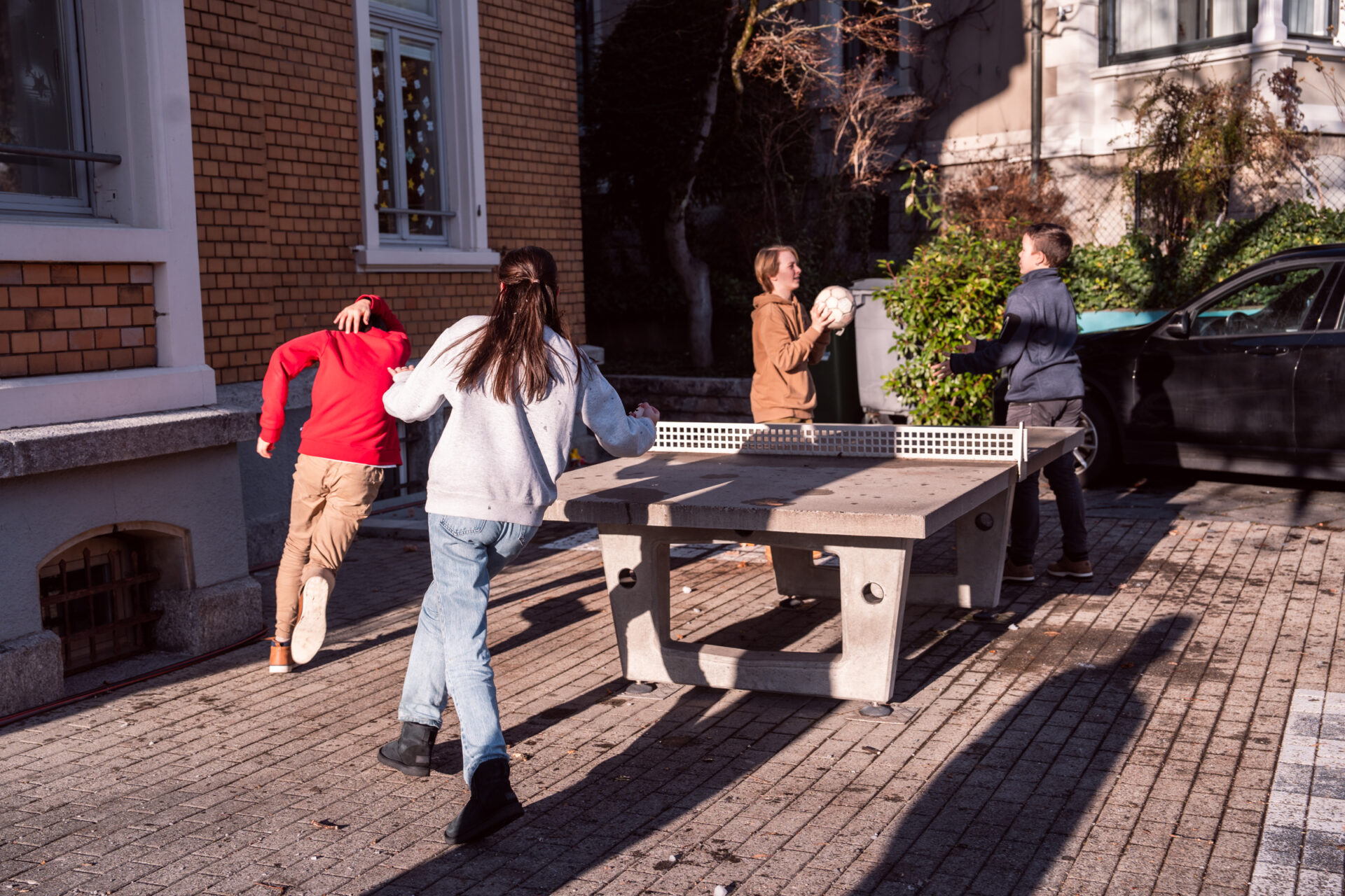 Kinder spielen Tischtennis im Garten der Villa